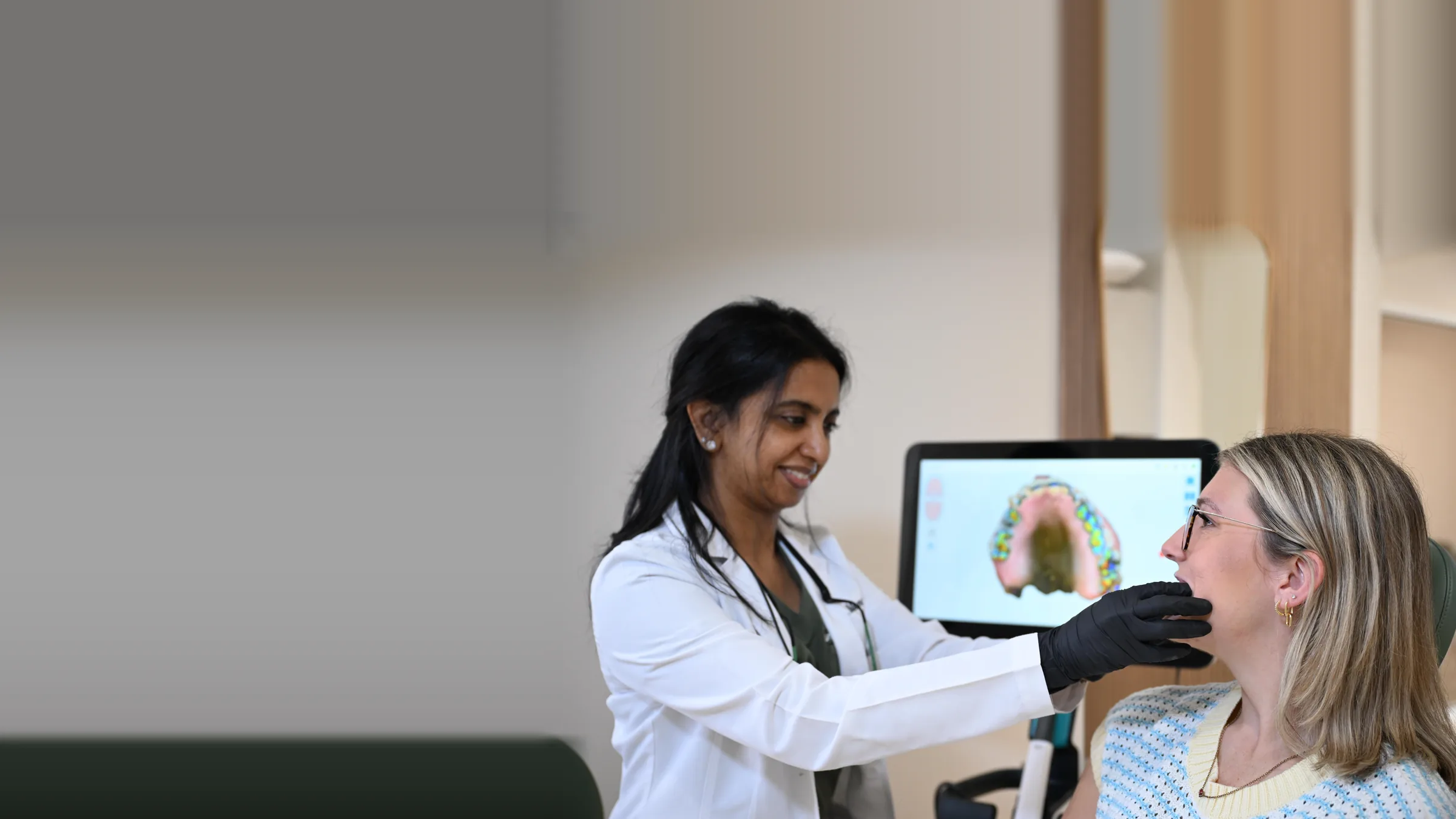 Dr. Meenachi Sellappan assessing a patient's bite with the digital bite map on screen at Smile Spot Dentistry, Venice FL