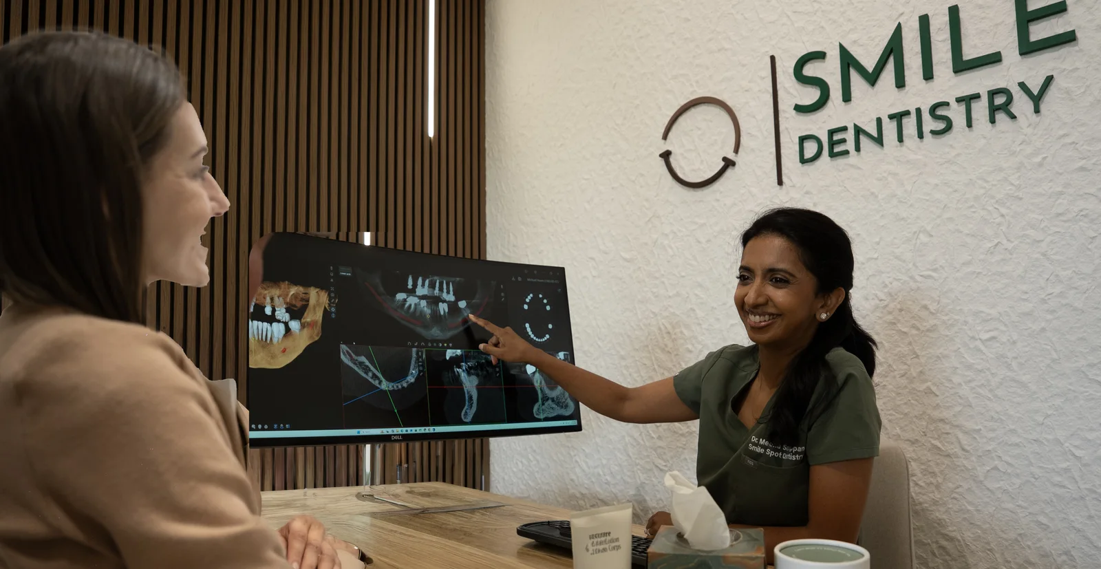Dr. Meenachi Sellappan reviewing a 3D CBCT scan with a new patient — Smile Spot Dentistry, Venice FL
