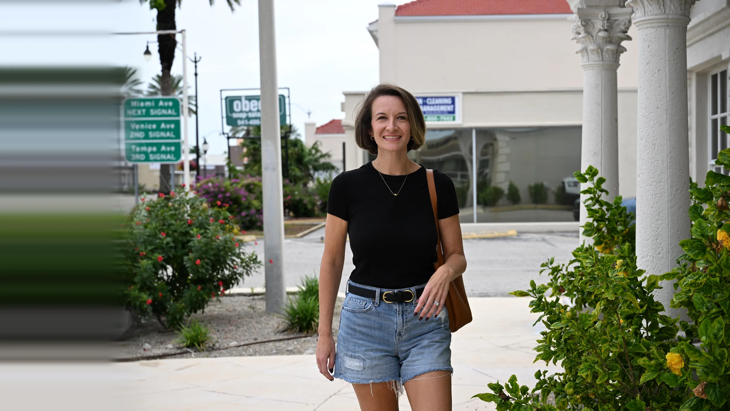 Smiling woman walking past the white colonnade in downtown Venice, Florida — Invisalign at Smile Spot Dentistry